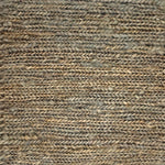 Close up of a rug in a sumak weave in green-brown