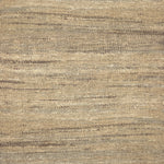 A close-up of a woven rug with a subtle striped texture in natural tan, beige, and brown tones.