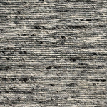Close up of a handwoven rug in textural sumak weave in black and white marled yarn.