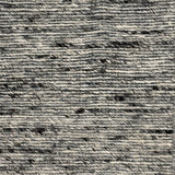 Close up of a handwoven rug in textural sumak weave in black and white marled yarn.