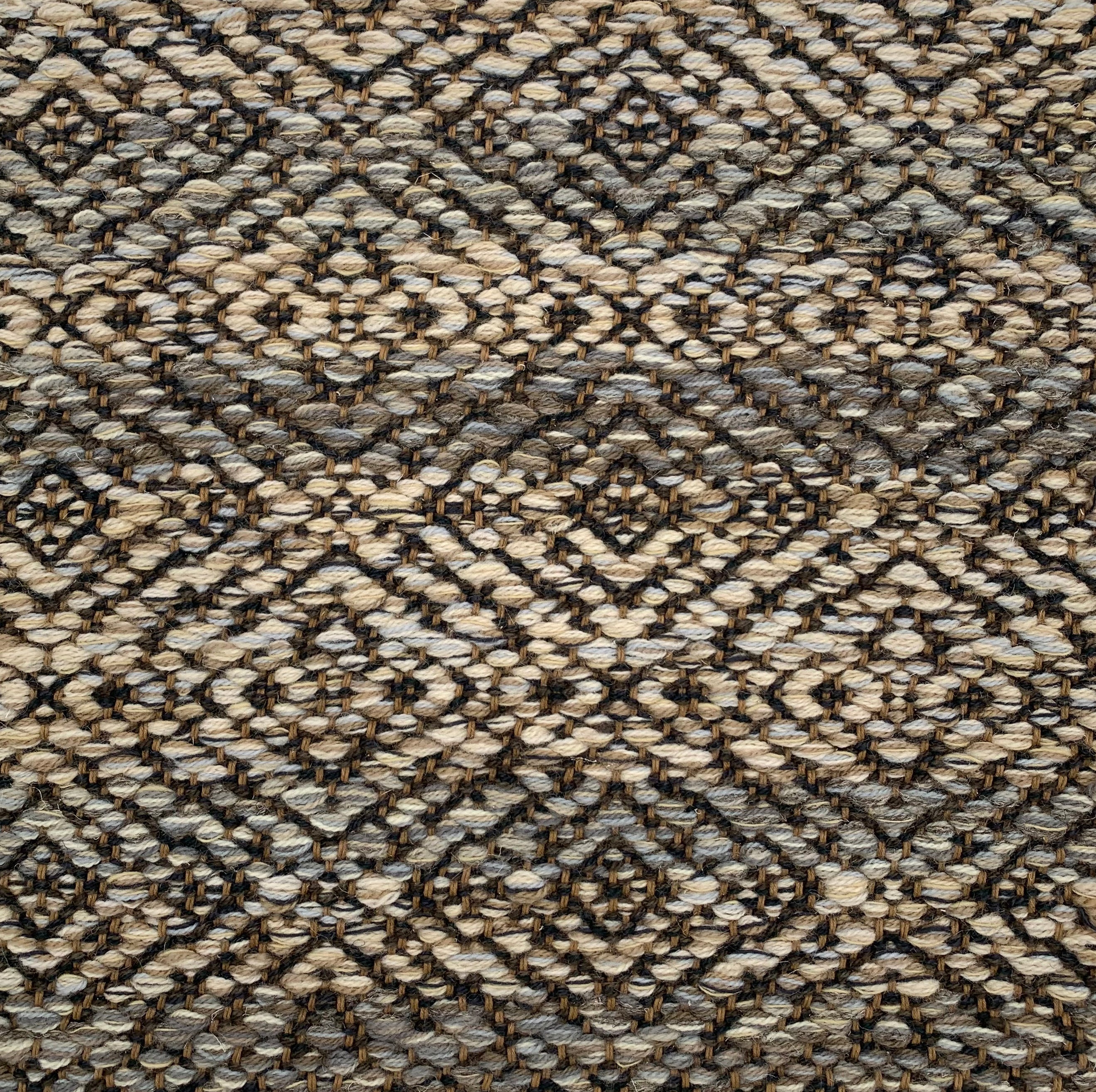 Handwoven rug detail in a contemporary design in cream, grey and brown