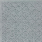 Handtufted rug sample with a repeating scallop pattern in muted blue-gray tones.