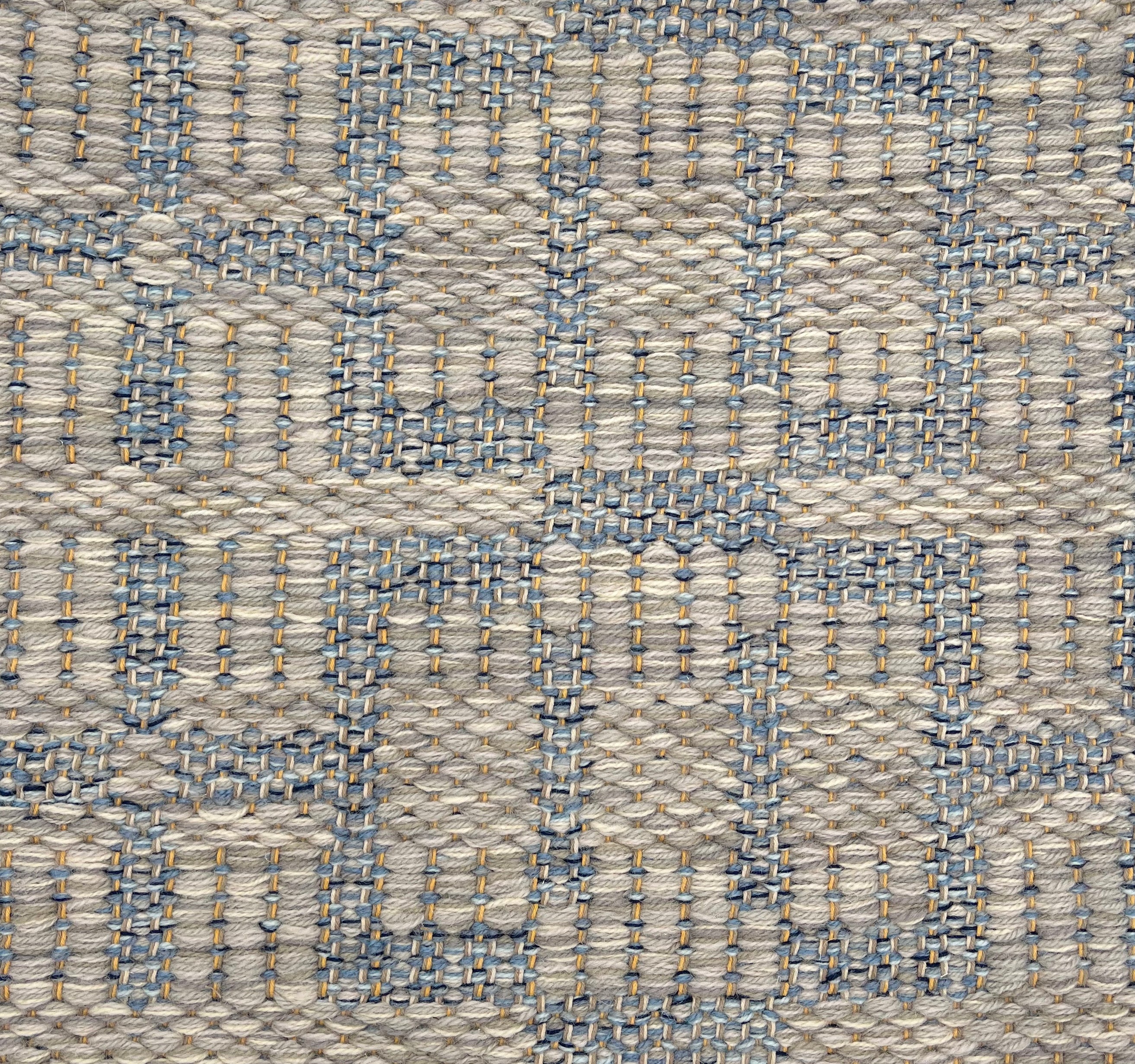 Handwoven rug detail in a contemporary design in blue and grey