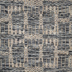 Handwoven rug detail in a geometric design in grey and beige