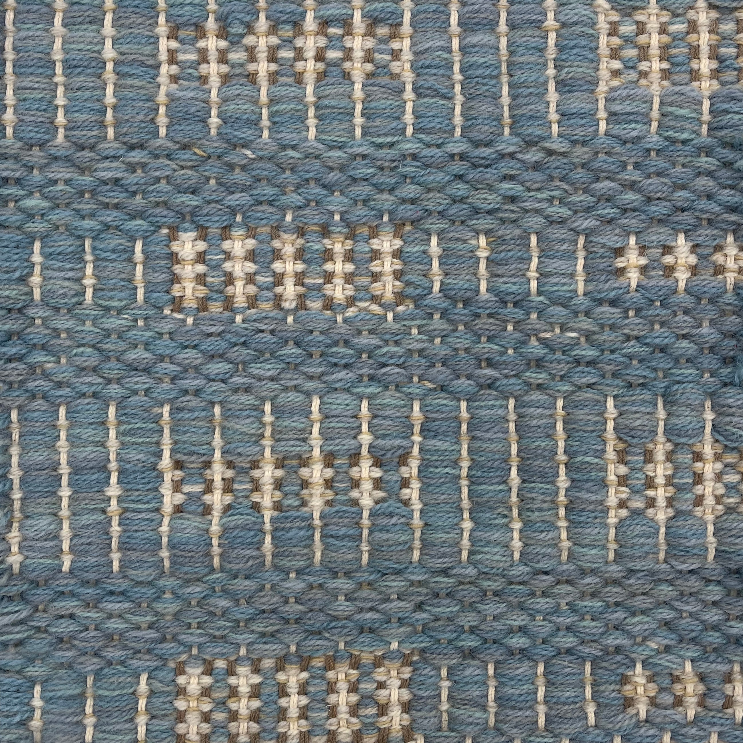 Handwoven rug detail in a contemporary striped design in blue, and cream