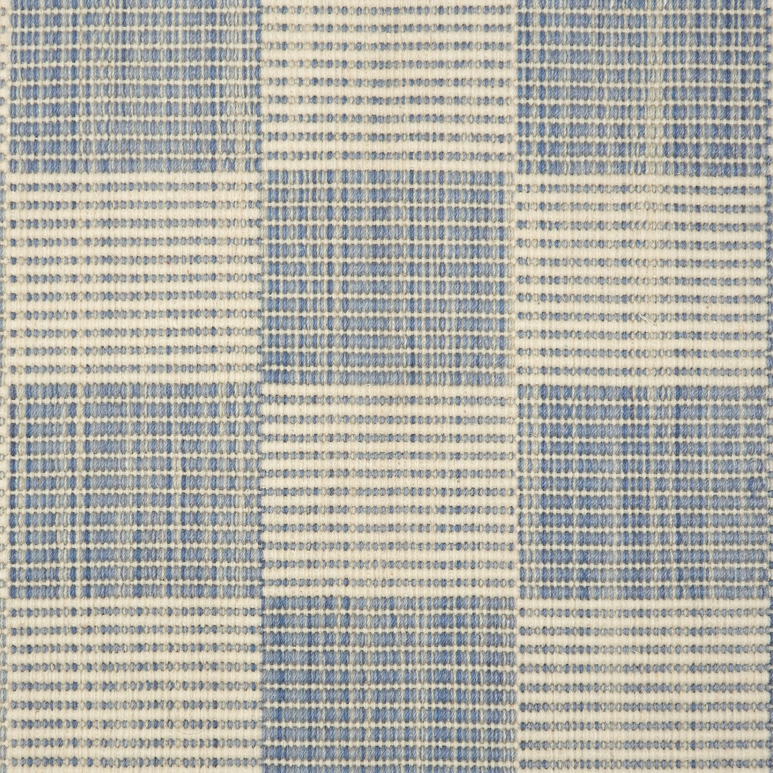 Broadloom carpet in a ribbed checkerboard pattern in cream and light blue. 