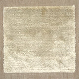Handloomed rug with neutral border and raised cut pile shag field in beige.