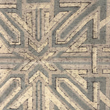 Geometric patterned rug with arrows in gray and beige tones