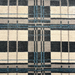 Handwoven rug in a bold windowpane plaid pattern in black, white, grey and blue. 