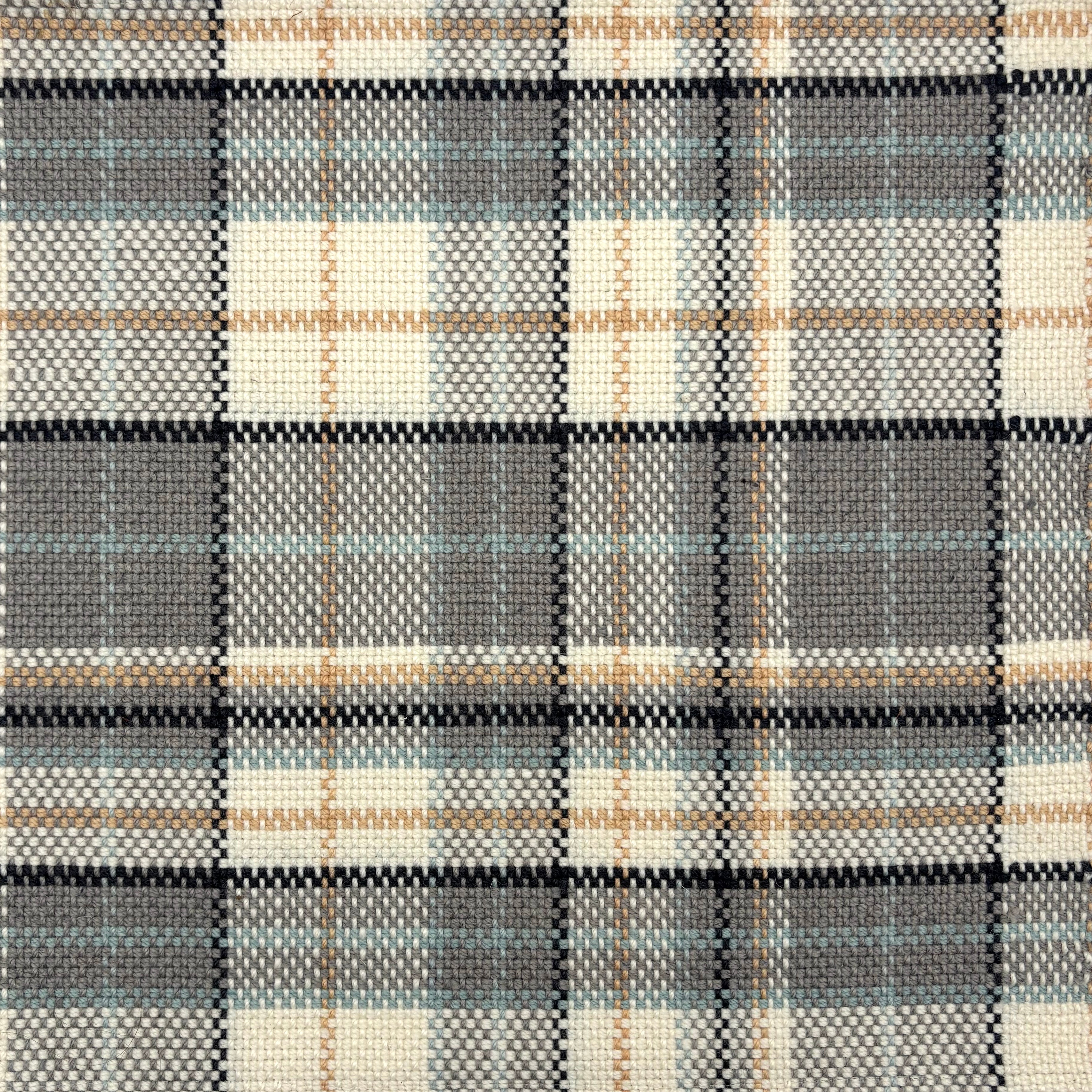 Flatwoven rug in a window pane pattern in cream, grey, tan, black and turquoise blue. 