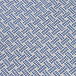 Close up of embroidered fabric with a basketweave design in blue on a white field. 