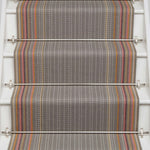 Striped flatweave runner in grey with pink orange and tan on white staircase