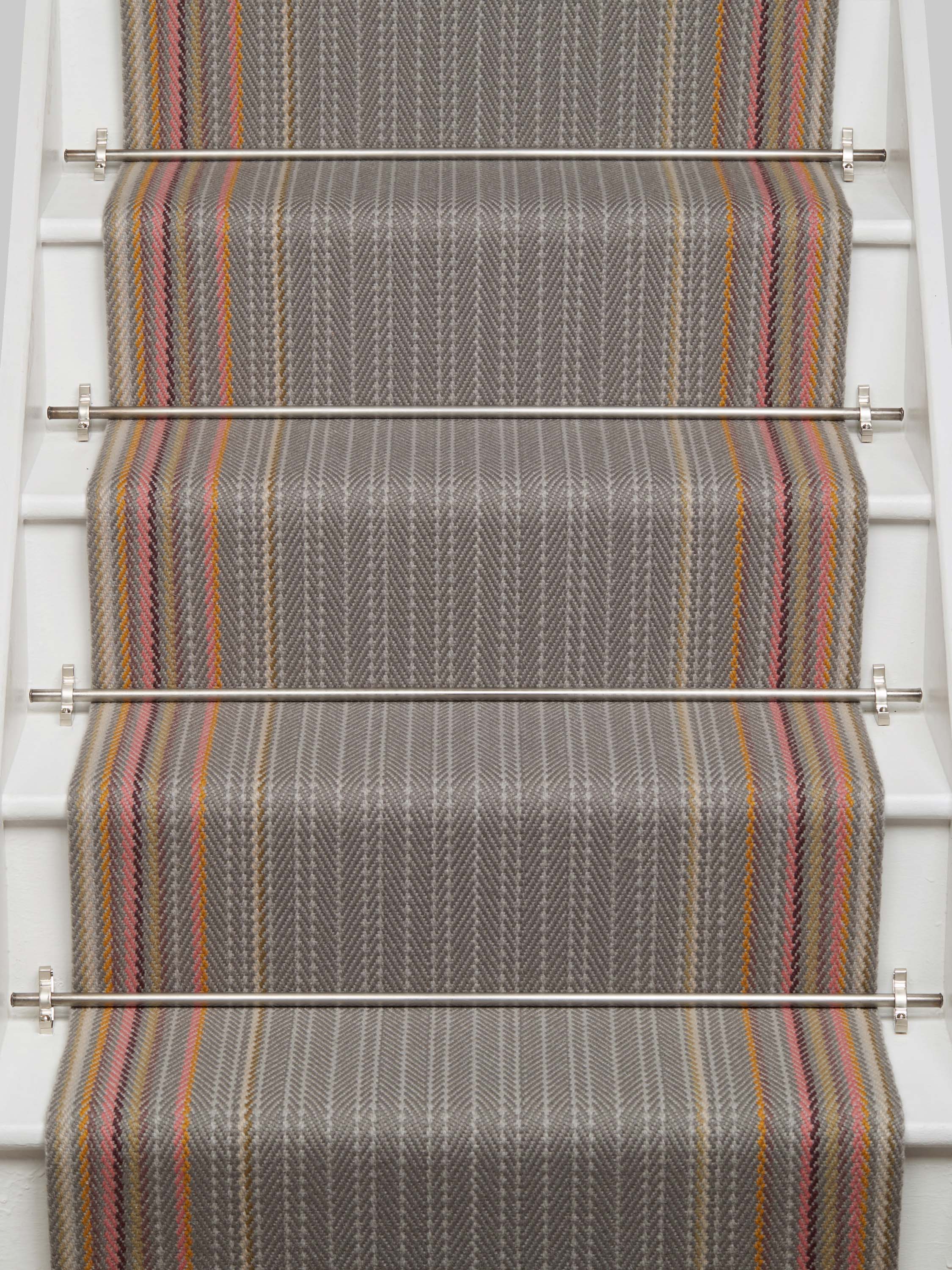 Striped flatweave runner in grey with pink orange and tan on white staircase