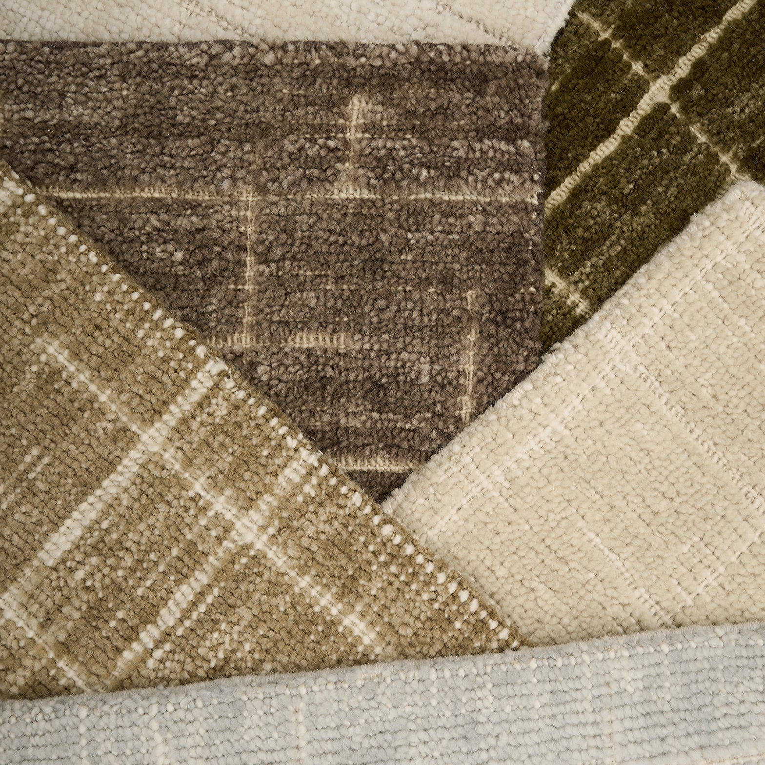 Close-up of textured carpet samples in brown, beige, and gray.