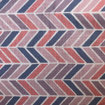 Detail of fabric in a geometric herringbone print in coral, purple and navy on a white field.