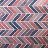 Detail of fabric in a geometric herringbone print in coral, purple and navy on a white field.