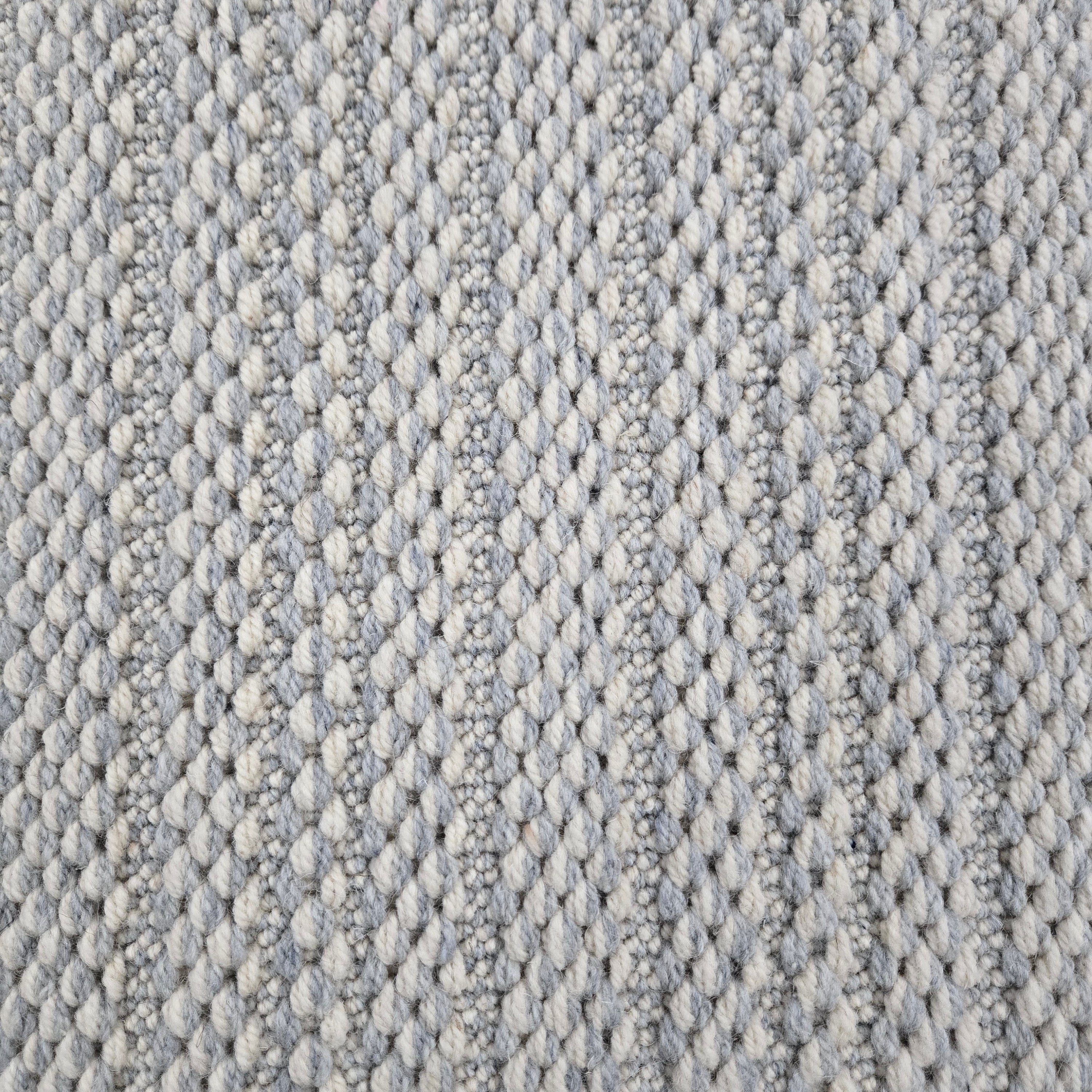Broadloom carpet in a textured stripe in white and cool blue. 
