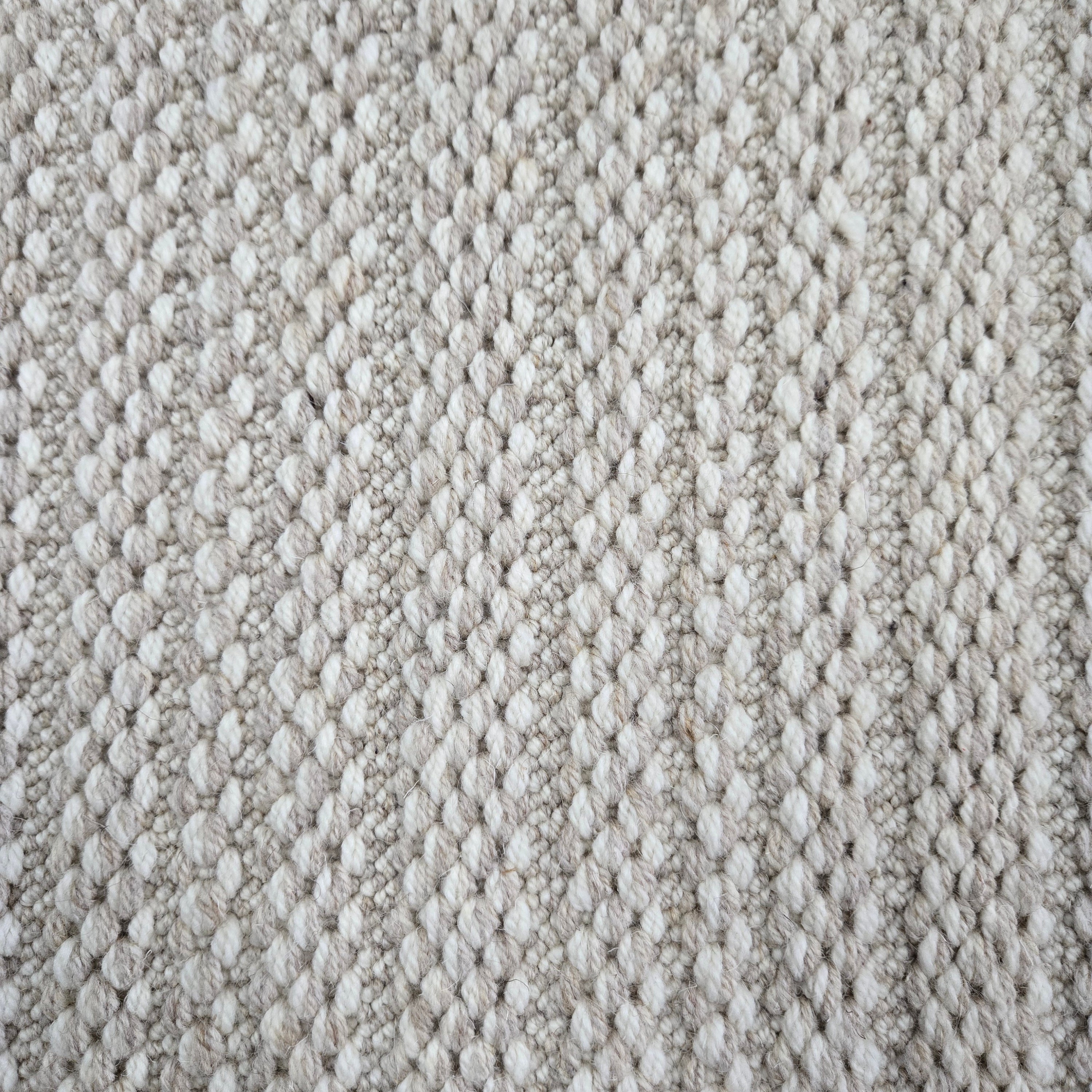 Broadloom carpet in a textured stripe in white and taupe. 