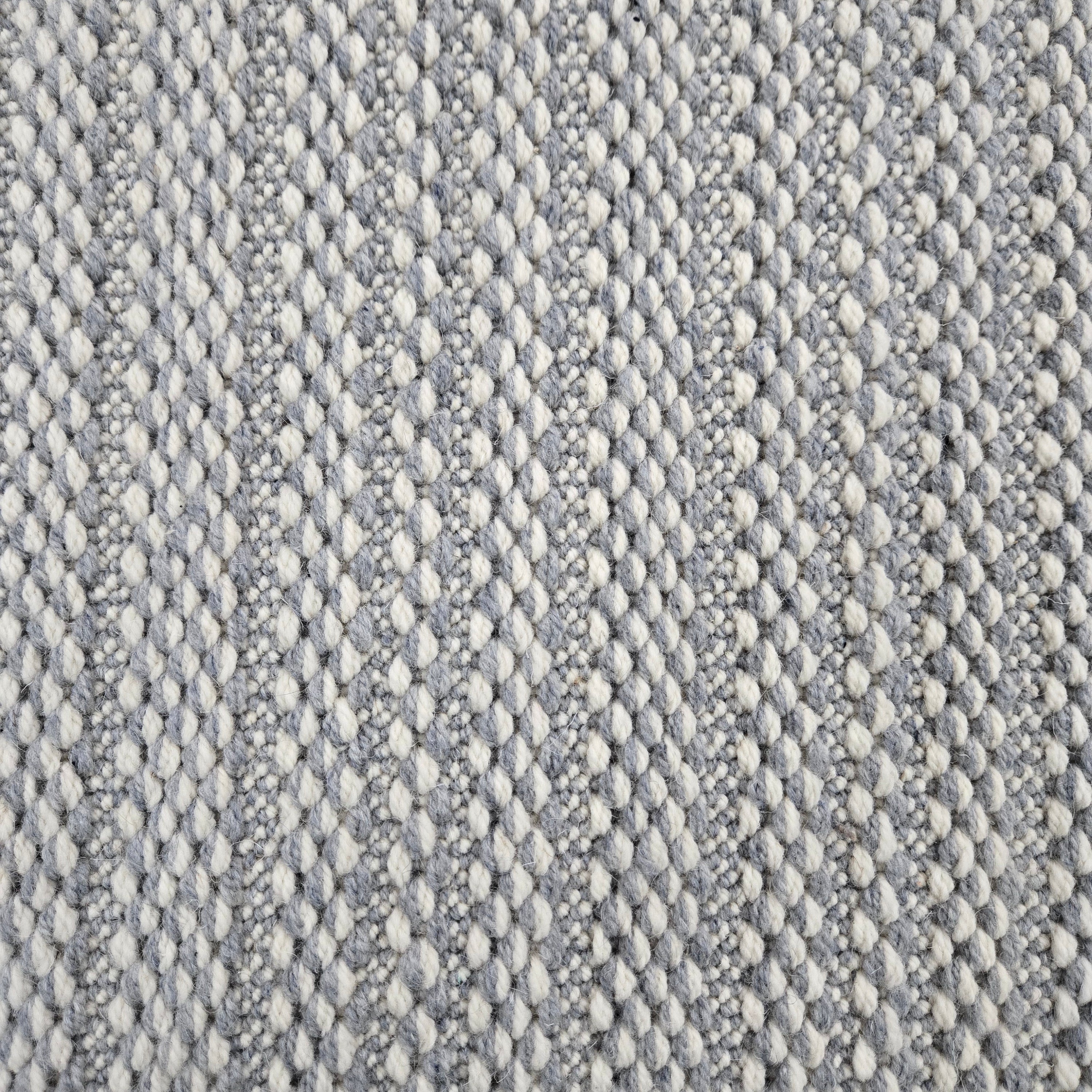Broadloom carpet in a textured stripe in white and steel blue. 