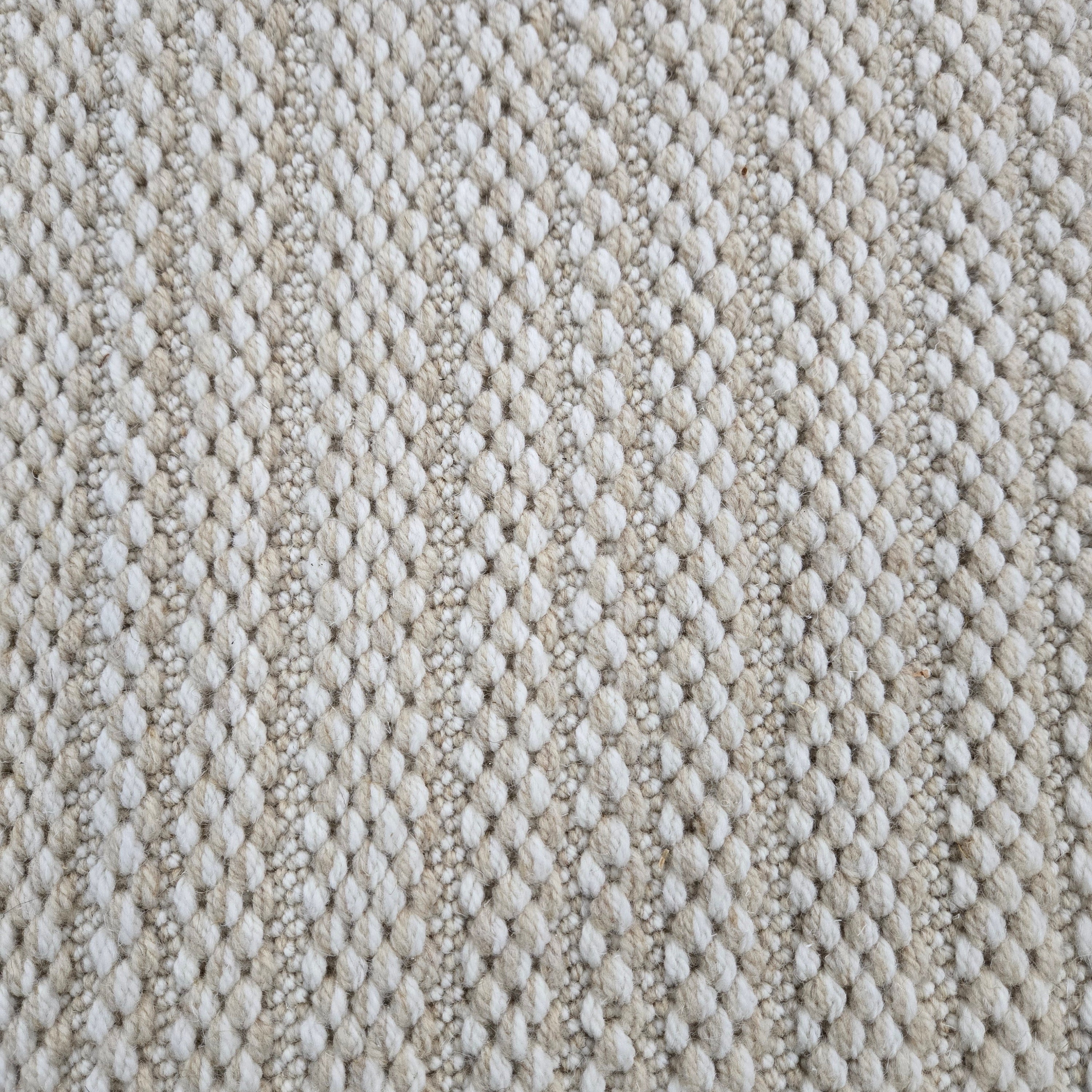 Broadloom carpet in a textured stripe in white and beige. 