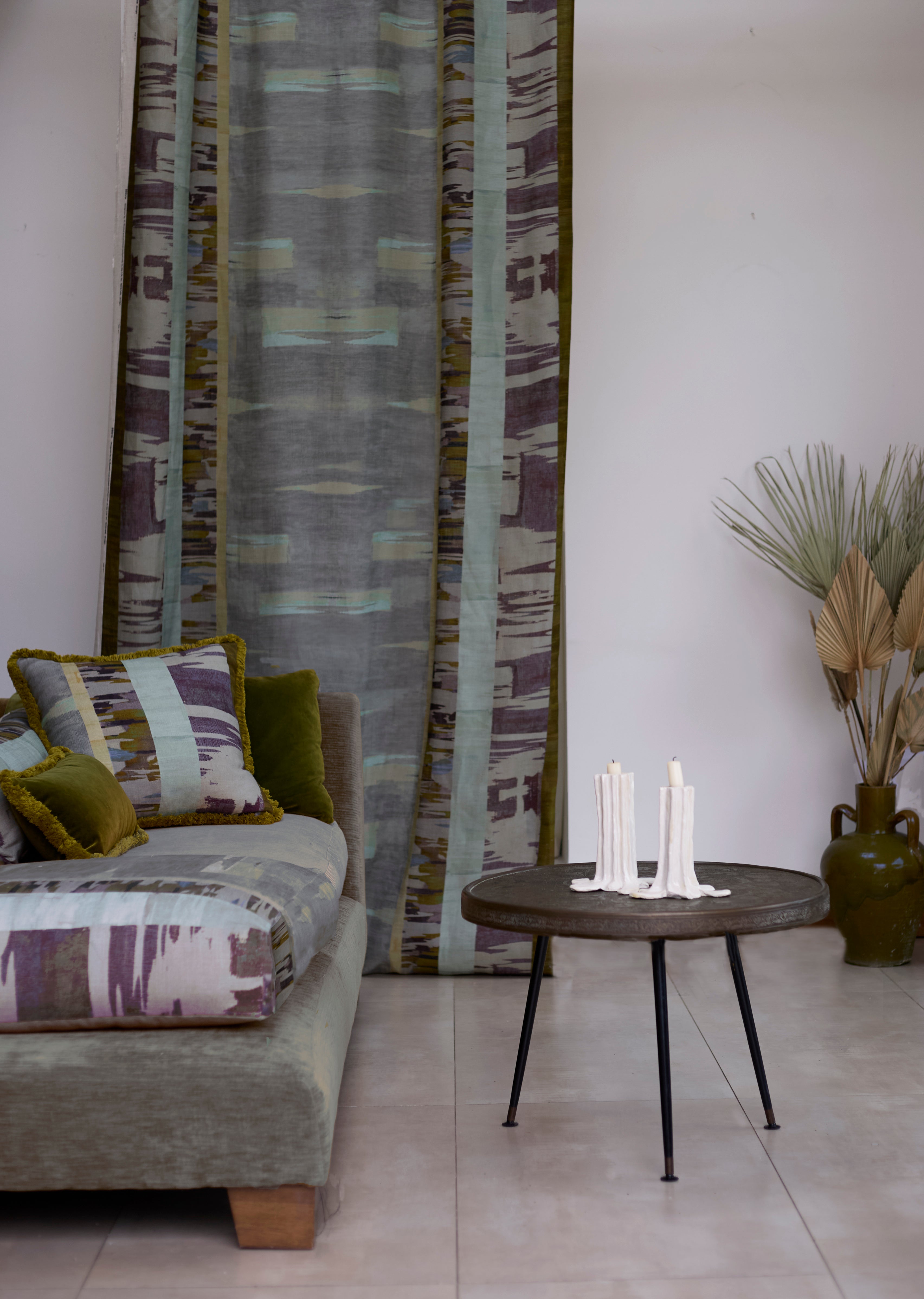 Living room with a couch in watercolor print, and a curtain panel in a matching design.