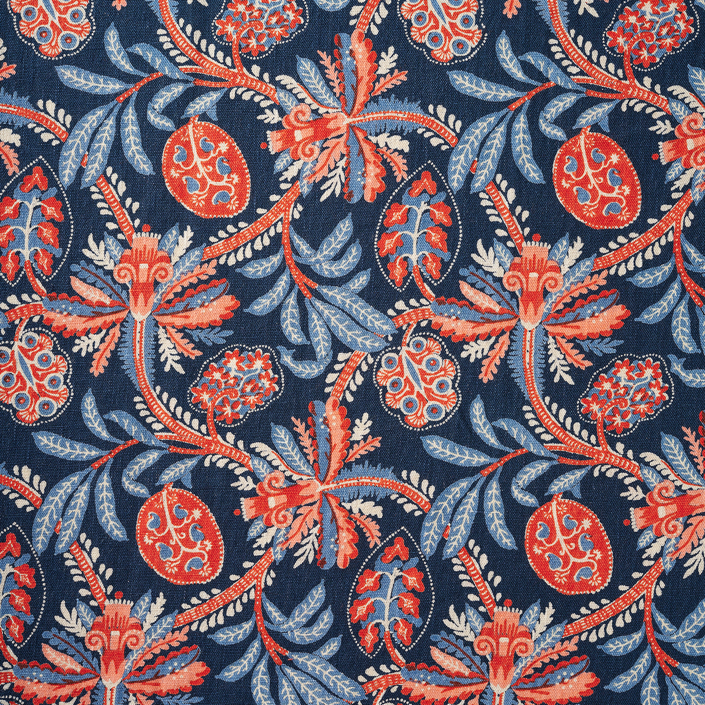 A close-up of a fabric pattern featuring stylized botanical motifs with coral-red and light blue flowers and leaves on a dark navy blue background.