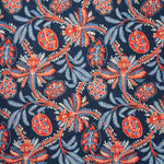 A close-up of a fabric pattern featuring stylized botanical motifs with coral-red and light blue flowers and leaves on a dark navy blue background.