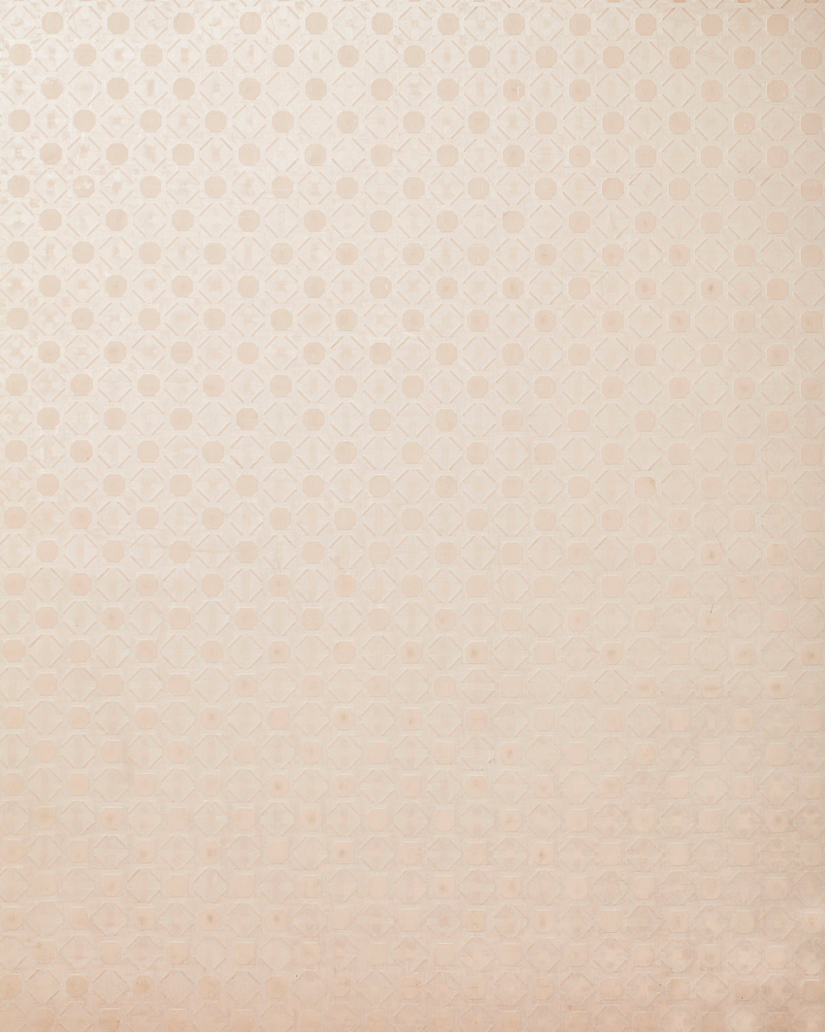 Detail of wallpaper in a honeycomb grid print in pastel pink on a cream field.
