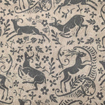 Detail of wallpaper in a deer, leaf and flower print in gray on a mottled tan field.