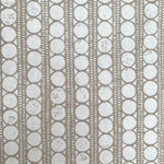 Detail of wallpaper in a circle and stripe print in white on a oatmeal field.