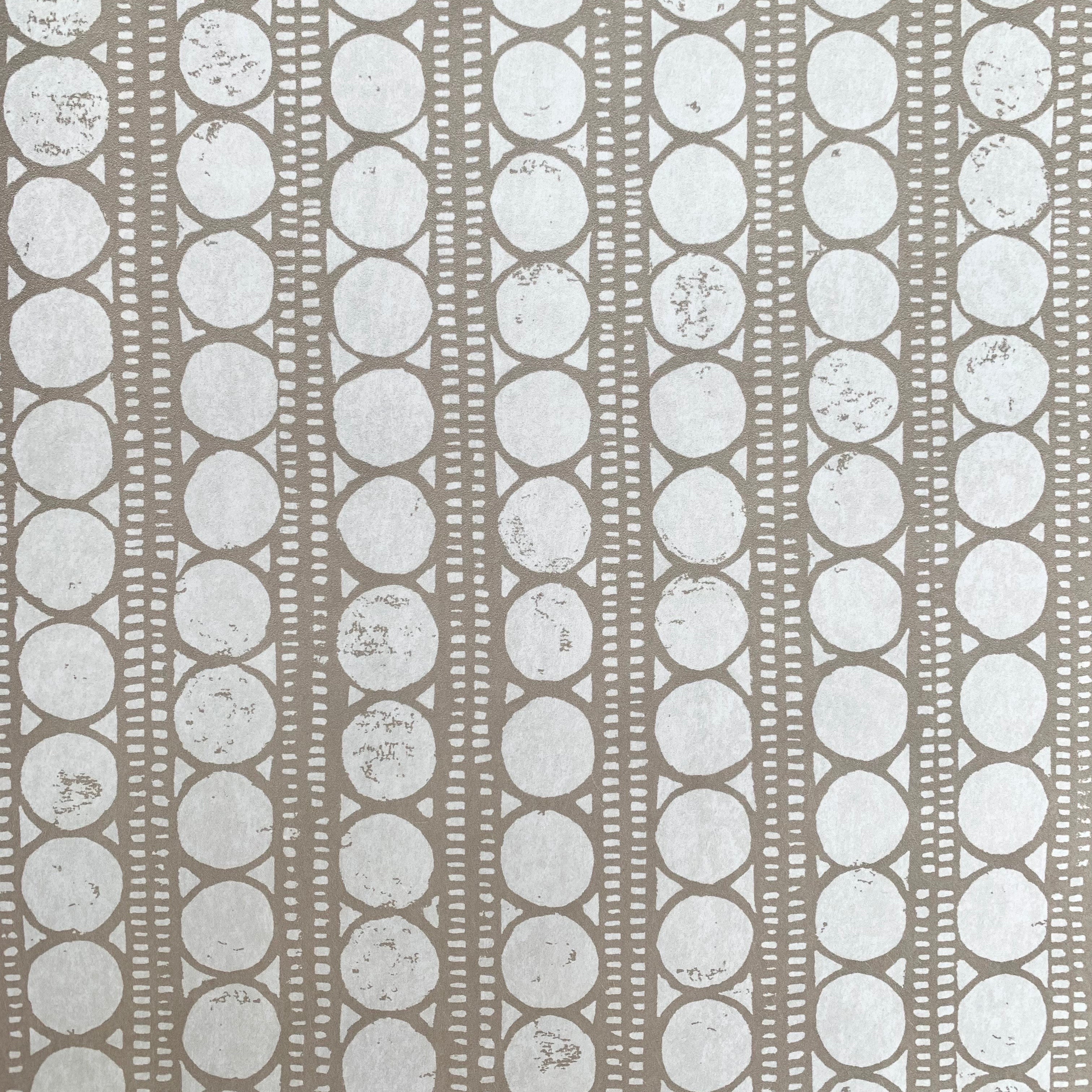 Detail of wallpaper in a circle and stripe print in white on a oatmeal field.