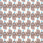 Detail of wallpaper in a playful hamsa hand print in brown, pink and blue on a white field.