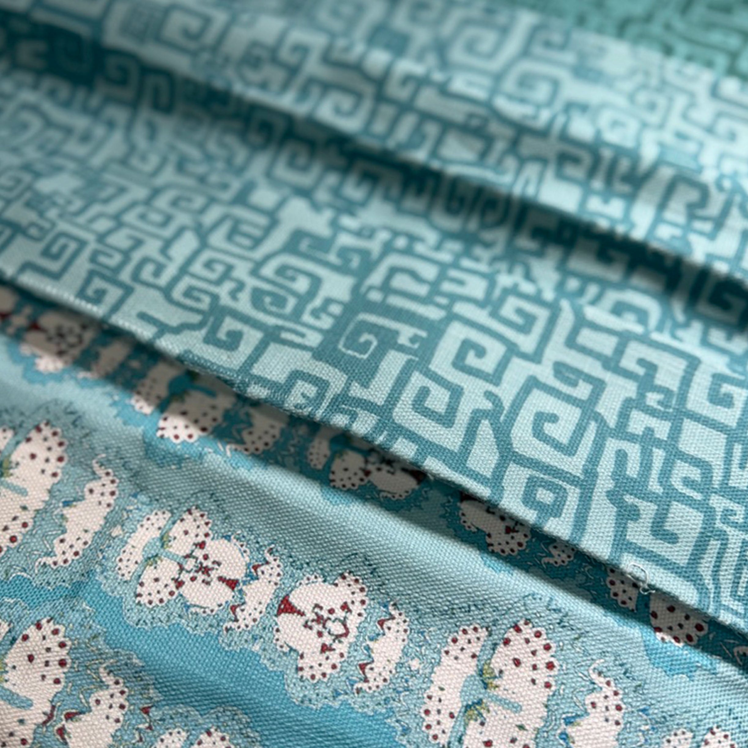 Stack of folded fabric swatches in various patterns in shades of blue
