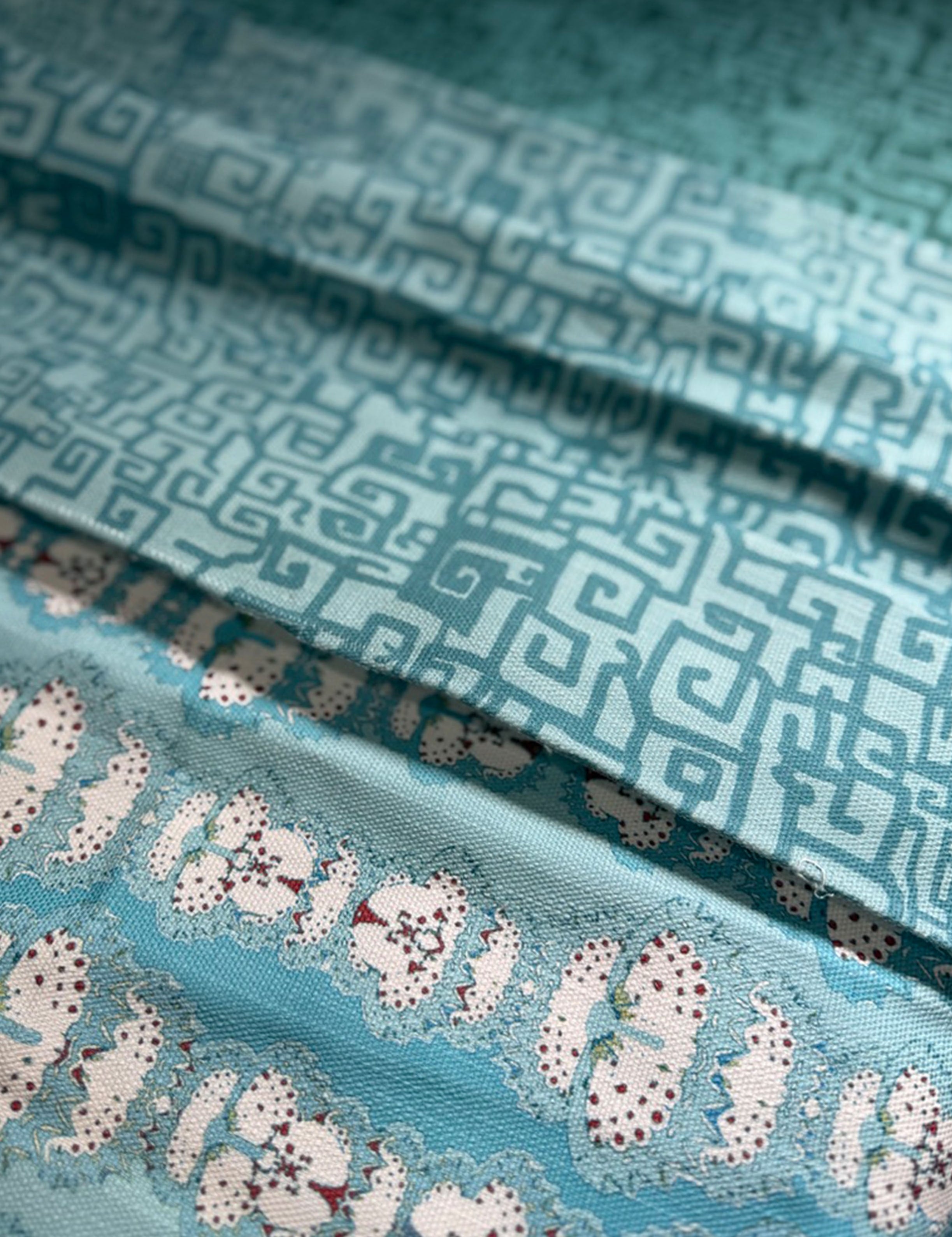 Stack of folded fabric swatches in various patterns in shades of blue