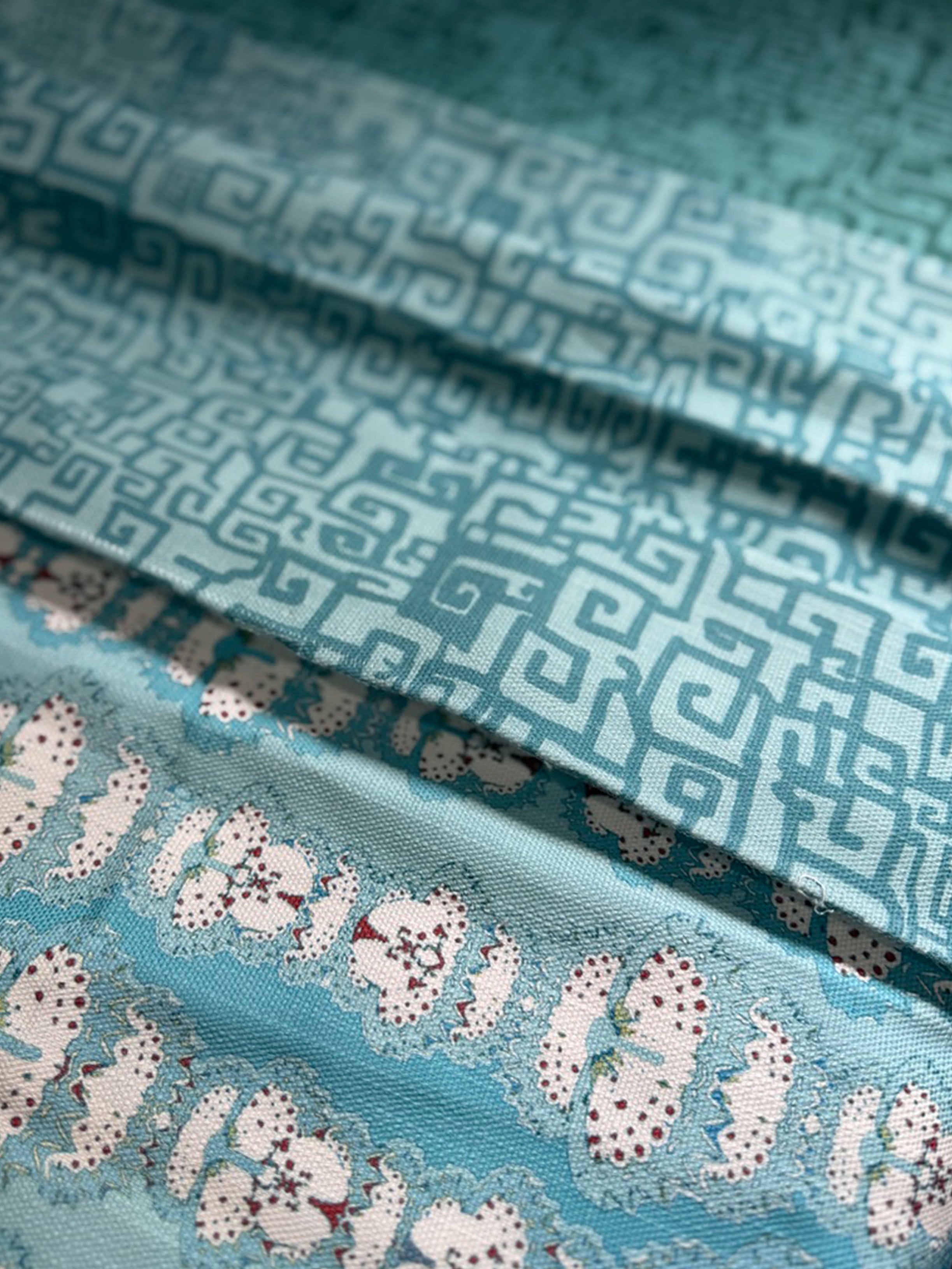 Stack of folded fabric swatches in various patterns in shades of blue
