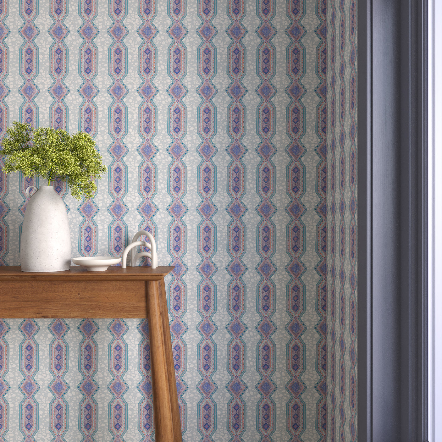 Interior with purple and blue geometric wallpaper and matching trim with a wooden console table with white ceramic vases with flowers. 