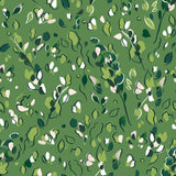 Detail of fabric in a painterly leaf print in shades of green and white on a kelly green field.