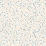 Detail of wallpaper in a painterly floral print in blue and white on a tan field.