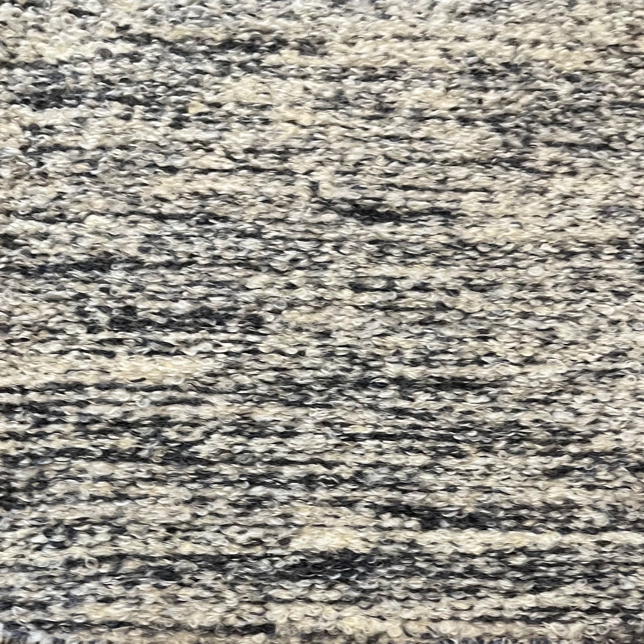 Textural bouclé broadloom carpet in charcoal and cream.
