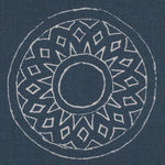 Detail of fabric in a repeating circular geometric print in light gray on a navy field.