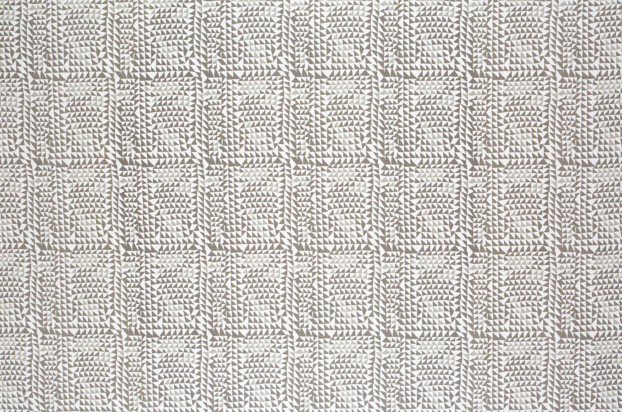 Detail of fabric in a dense triangle grid print in shades of brown on a white field.