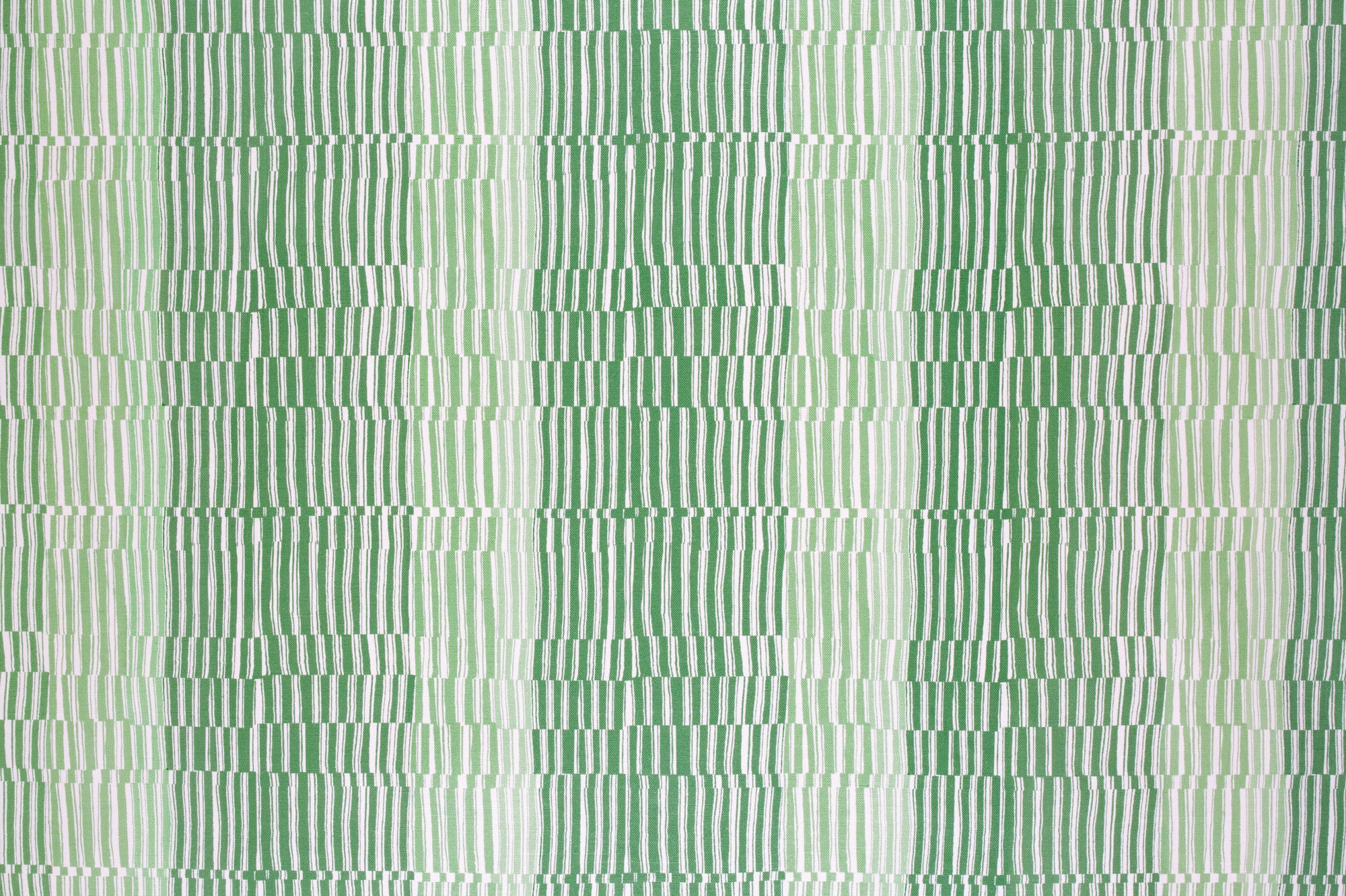Detail of fabric in a dense broken stripe print in shades of green and white.
