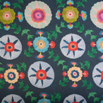 Detail of fabric in a playful floral pattern in a rainbow of colors on a navy field.