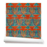 Wallpaper roll with a stamped painted floral motif in vibrant red and cobalt on an emerald green background