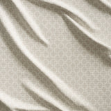 Close up of gently draped woven Indoor-Outdoor fabric with dense floral medallion pattern in beige on white. 