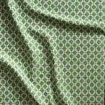 Close up of gently draped woven Indoor-Outdoor fabric with dense floral medallion pattern in grass green on white. 