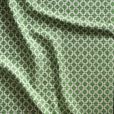 Close up of gently draped woven Indoor-Outdoor fabric with dense floral medallion pattern in grass green on white. 