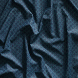 Close up of gently draped printed linen with dense floral medallion pattern in tonal dark blue.