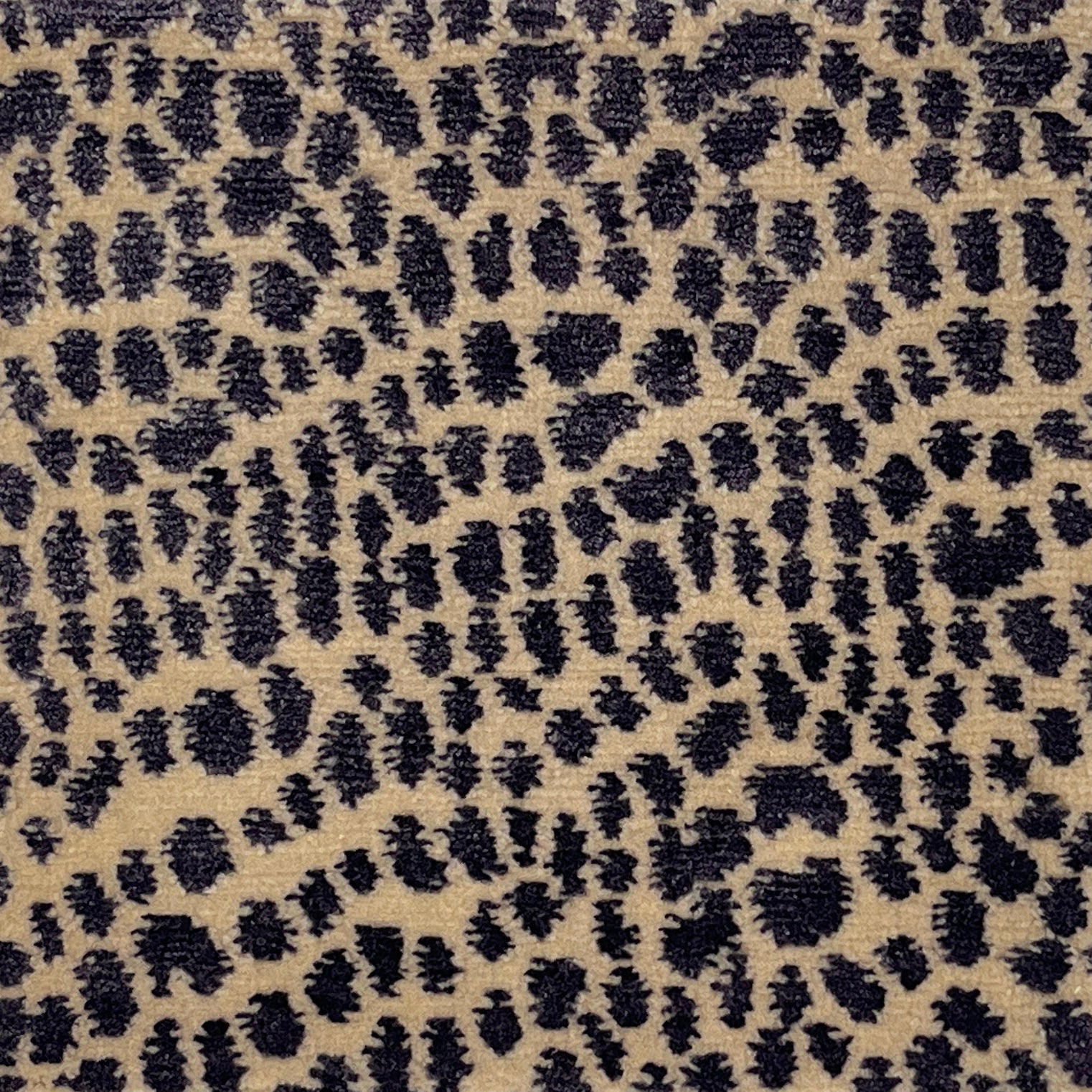 Handknotted rug with animal skin motif in purple on cream. 