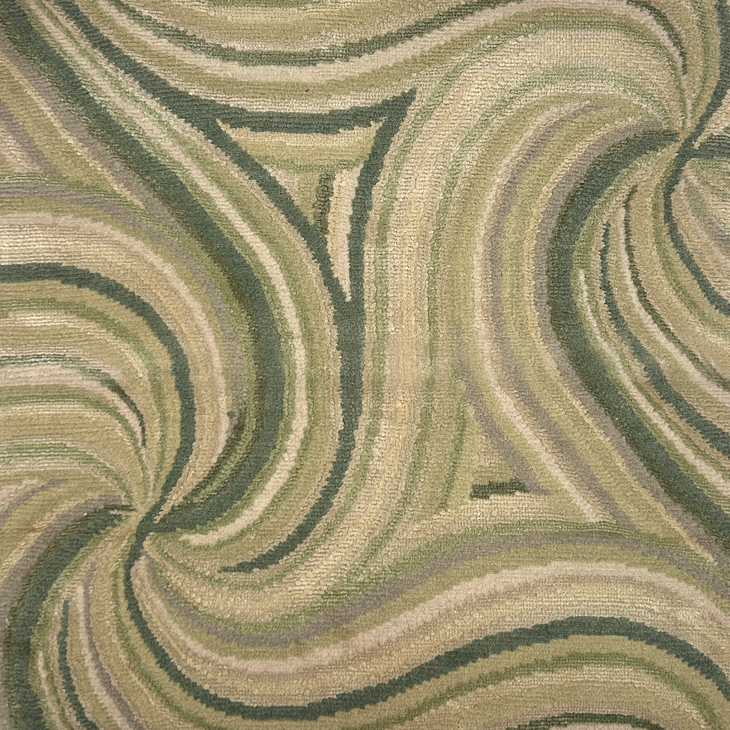 Handknotted rug with an abstract linear swirl design in shades of green. 